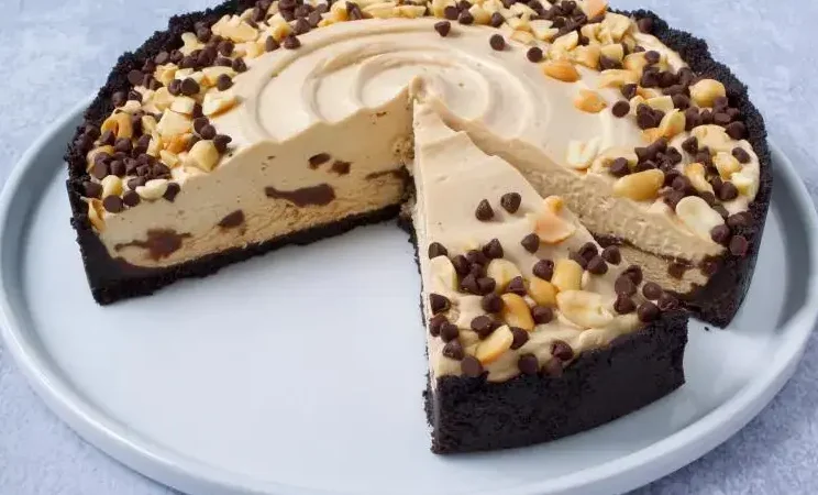 A luscious peanut butter ganache being poured over a moist chocolate cake on a kitchen counter.