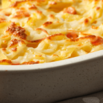 Freshly baked ricotta ravioli casserole in a glass dish, golden brown and cheesy.